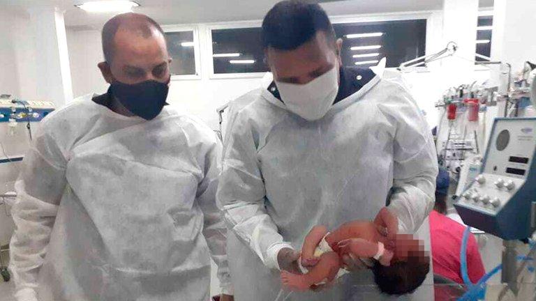 Médicos revisando a bebé