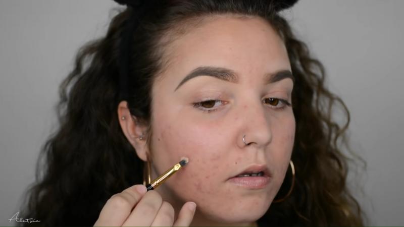 Poniendo corrector en el rostro