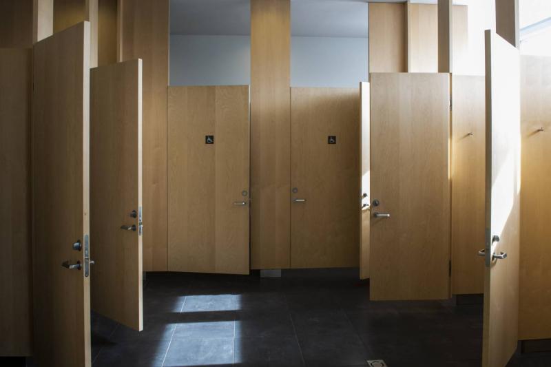 Por qué las puertas de los baños públicos no llegan al suelo