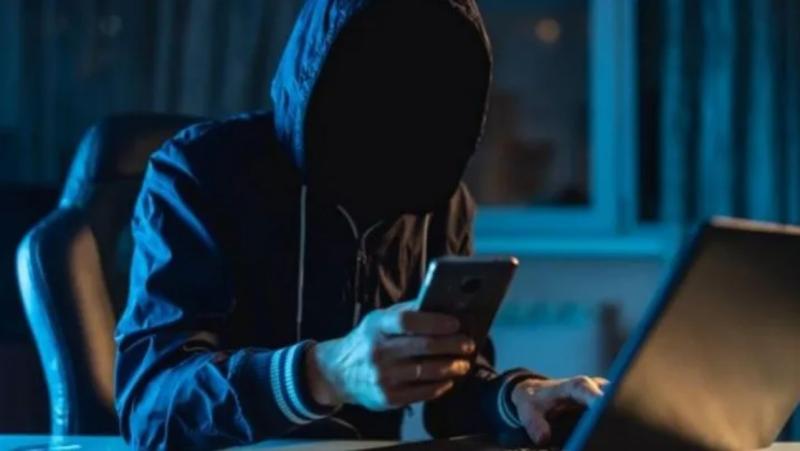 Hombre con polerón y capucha mirando el celular