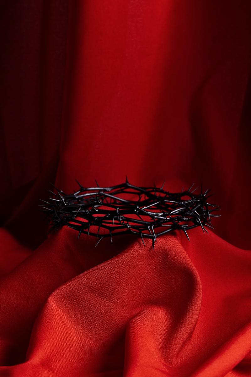 Corona de espinas en un manto rojo de fondo