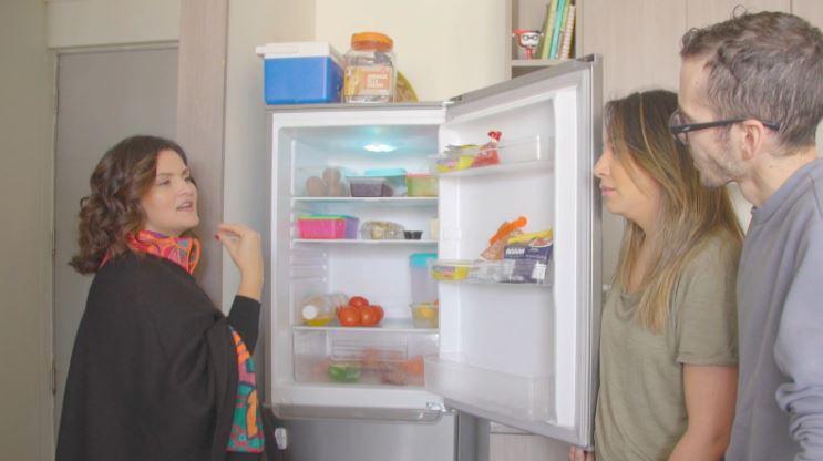 Connie Achurra revisando el refri del matrimonio en su departamento.