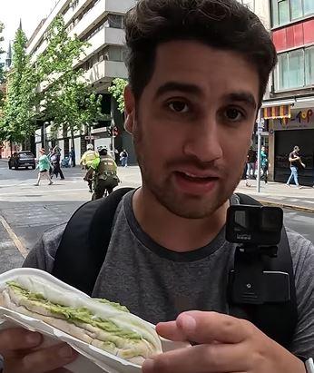 “Me arrepiento tanto”: Youtuber probó los completos por primera vez y esta fue su reacción