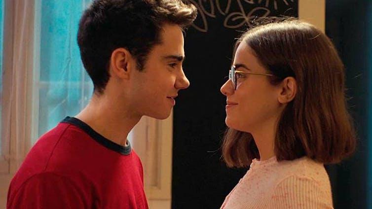 Un chico adolescente mira fijamente a una chica.