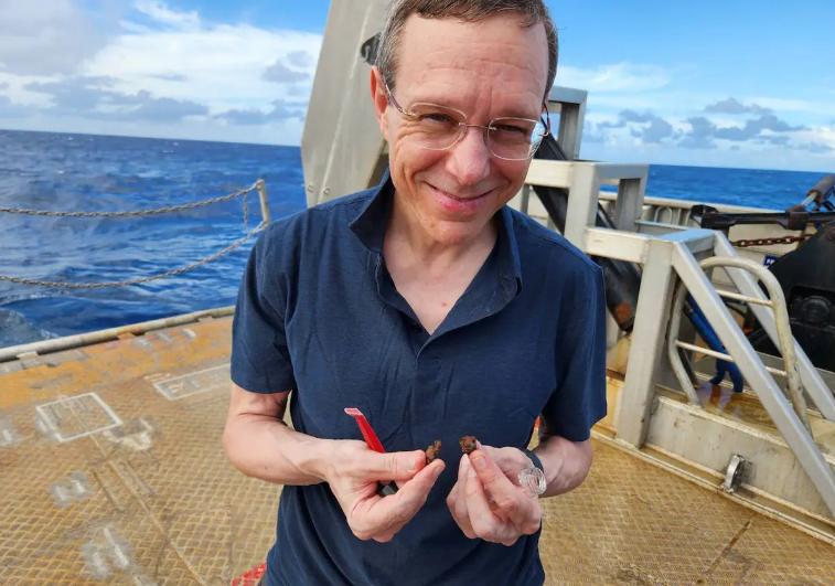 Avi Loeb sujetando unos pequeños restos de lo que él sostiene son parte de una nave extraterrestre. Créditos: Avi Loeb