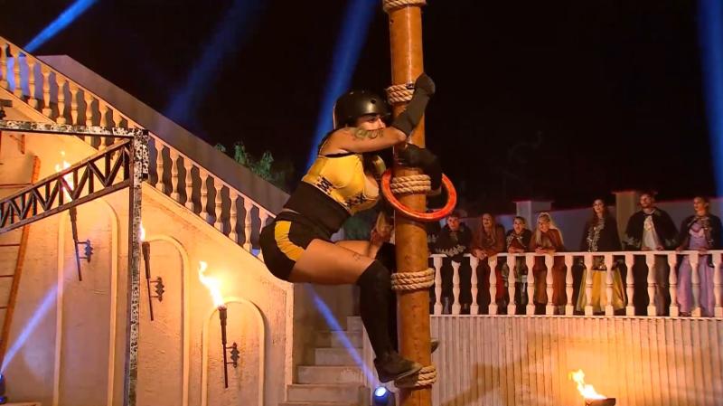 Blue Mary intenta pasar una argolla por el poste en Ganar o Servir