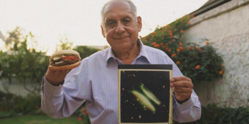 Arturo Gómez con una hamburguesa y una foto de la nebulosa de Gómez. Créditos: Campaña publicitaria de Burger King.