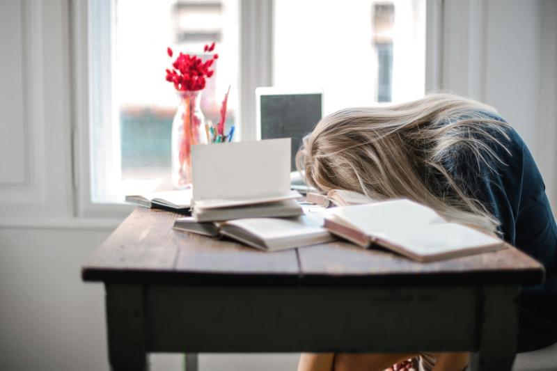 Mujer dormida sobre su escritorio. Créditos: Pexels.