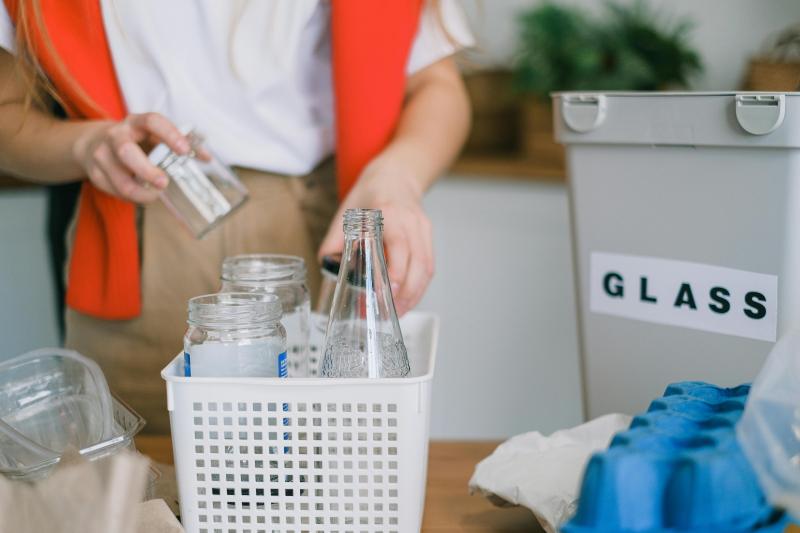 Persona recicla botellas de vidrio. Créditos: Pexels.