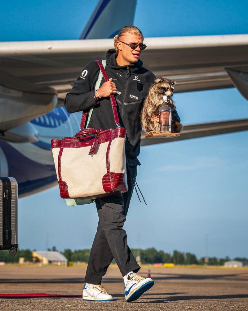 Haaland en el aeropuerto con su mapache disecado sosteniendo una botella de whisky | Instagram