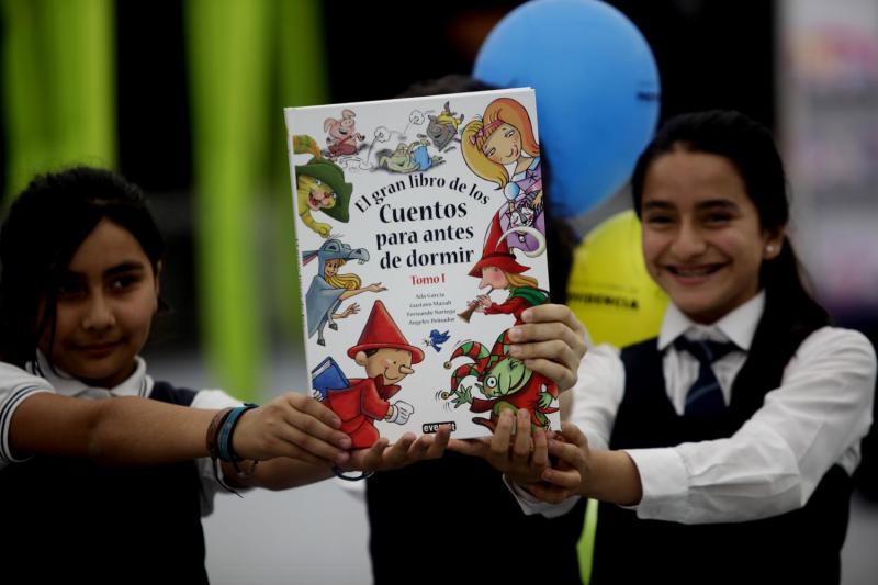 Niñas con libro de cuentos infantiles en la mano / Agencia Uno.