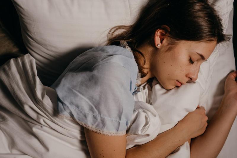 Mujer duerme en una cama / Pexels