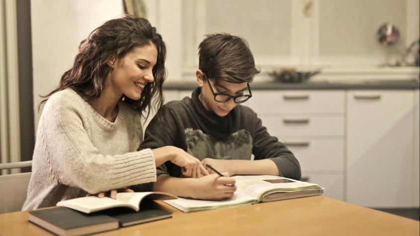 Madre e hijo leyendo un libro. Créditos: Pexels. 