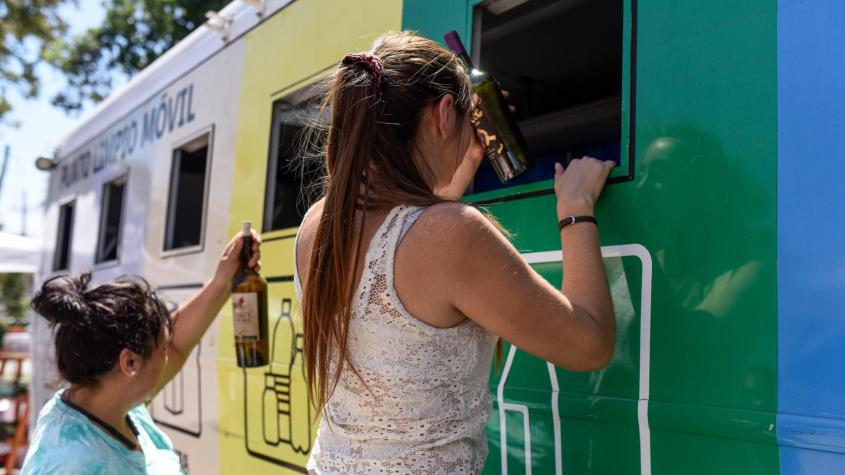 Mujeres dejan botellas de vidrio en punto de reciclaje. Créditos: Agencia UNO. 