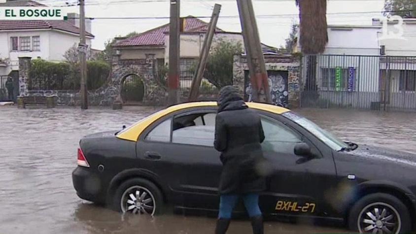 Taxi con pasajeros quedó atrapado en calle anegada en El Bosque 