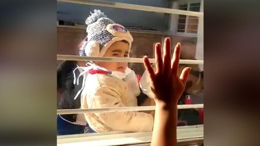 Mujer con coronavirus se despide de su hijo a través de una ventana