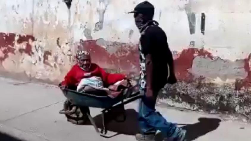 Hijo lleva a su mamá en carretilla para recibir vacuna contra el Covid
