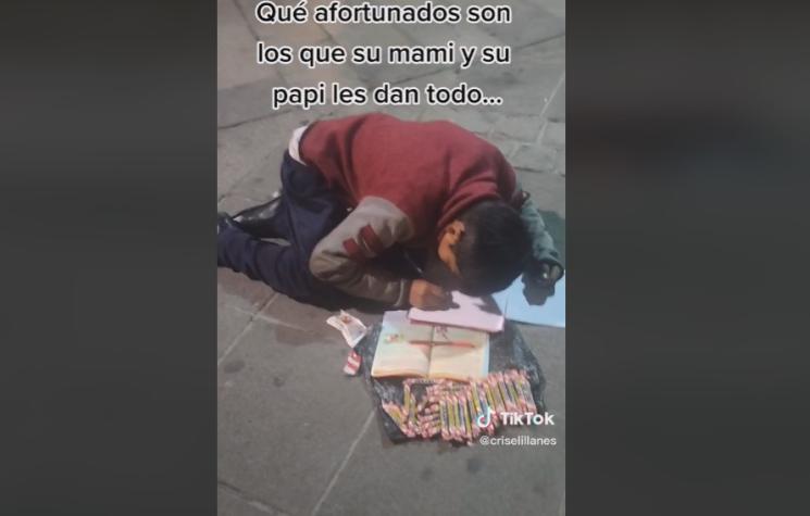 Triste realidad: niño hace su tarea mientras vende dulces en la calle