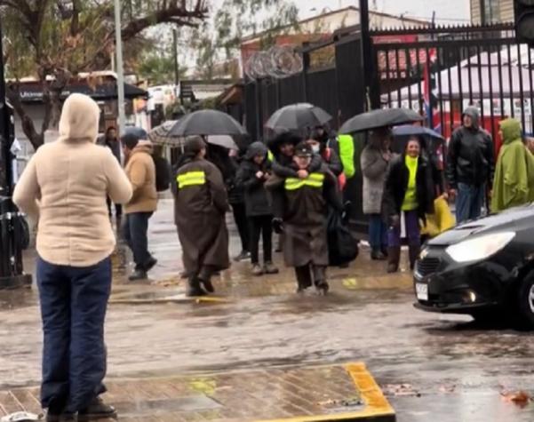 Se viraliza registro de Carabineros llevando transeúntes "al apa" para cruzar calle inundada