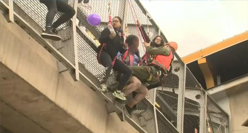 Pobladores se cuelgan de pasarela en el Metro Las Torres